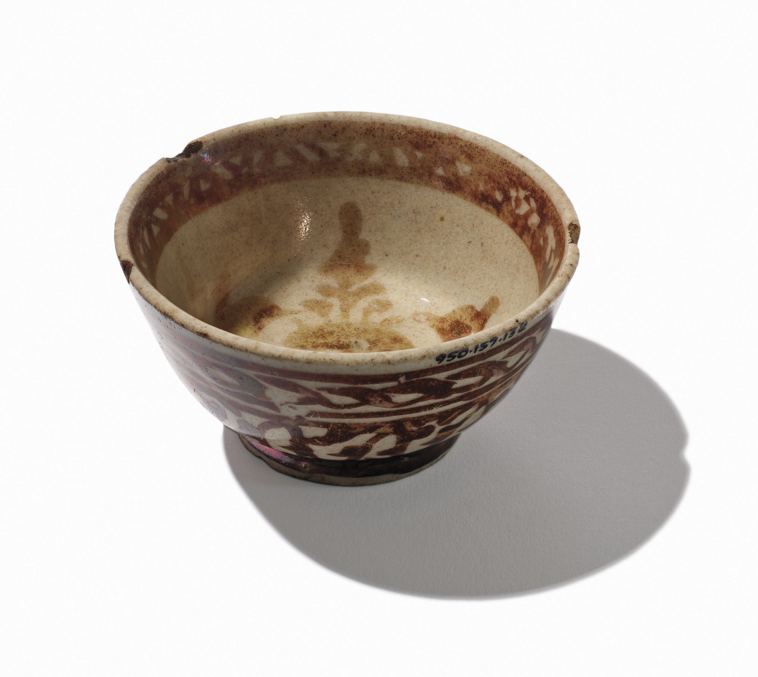 Ceramic bowl with brown floral patterns and a beige interior, casting a shadow on a white background.