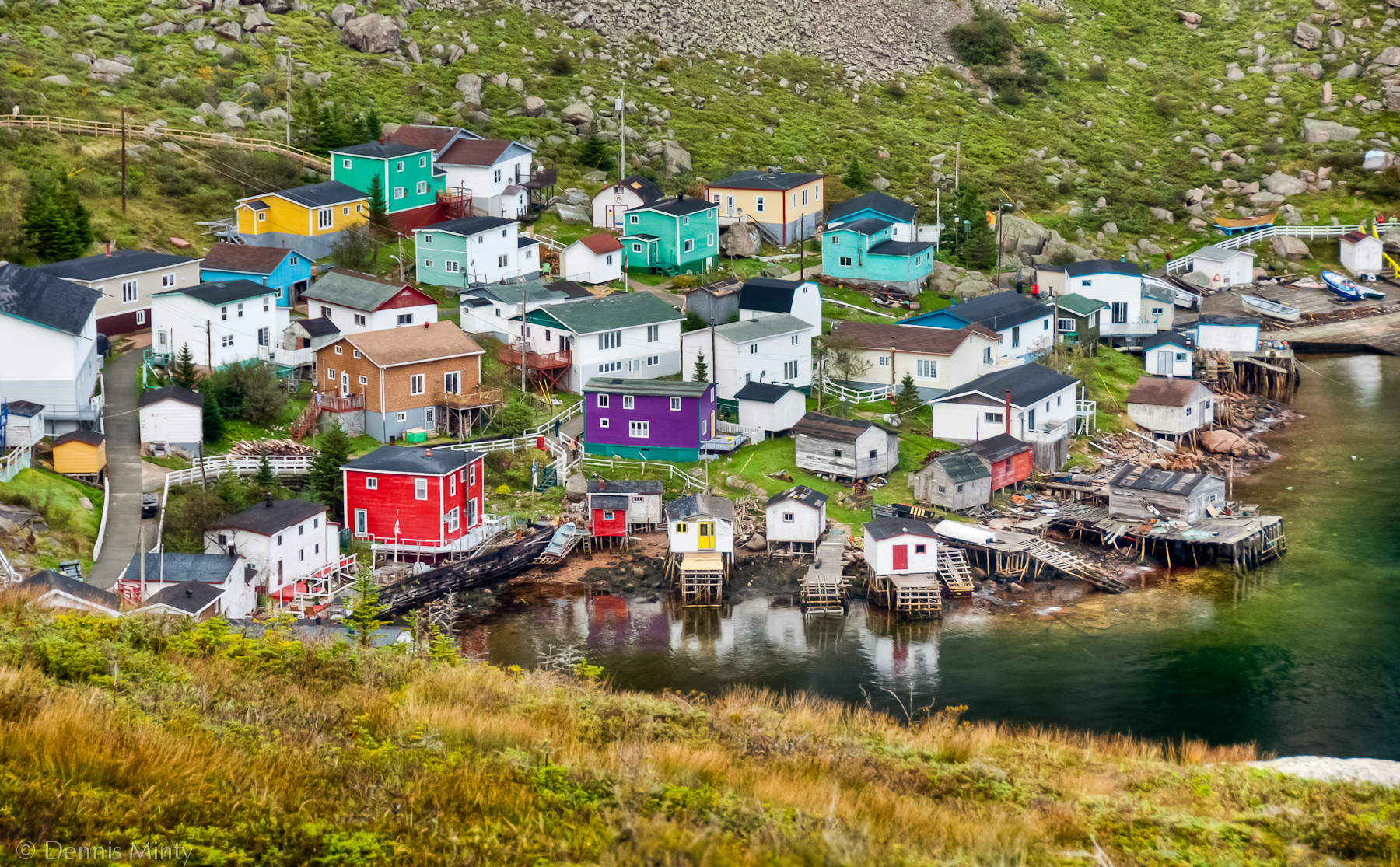 Un groupe de maisons colorées sur une colline au bord de la mer.