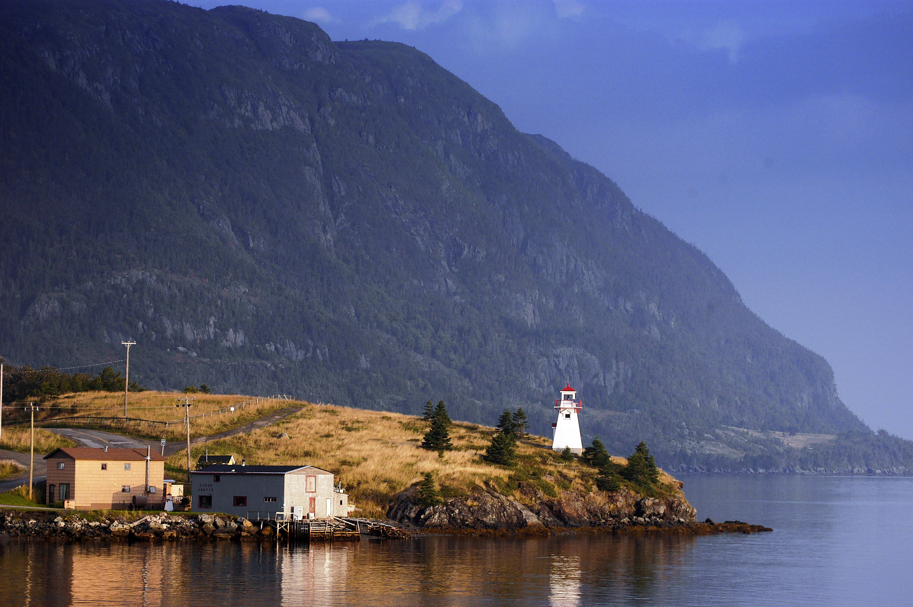 Un phare avec une montagne en arrière-plan.