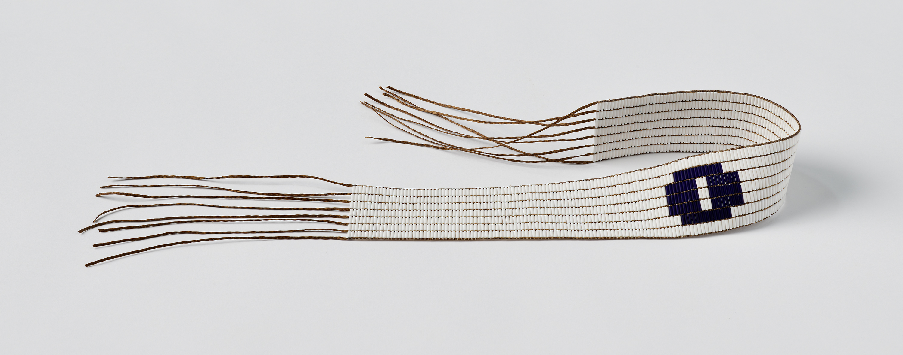 A white beaded belt with a purple circle on it