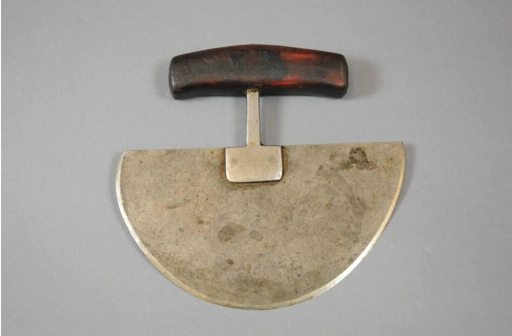 Couteau dont la lame métallique en forme de demi-cercle est reliée à un manche en bois.