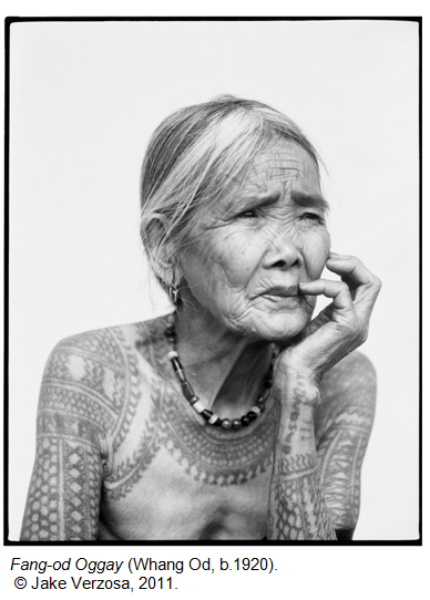 Fang-o d'Oggay (Whang Od, vers 1920), femme âgée avec des tatouages traditionnels sur les bras, main posée sur le visage.