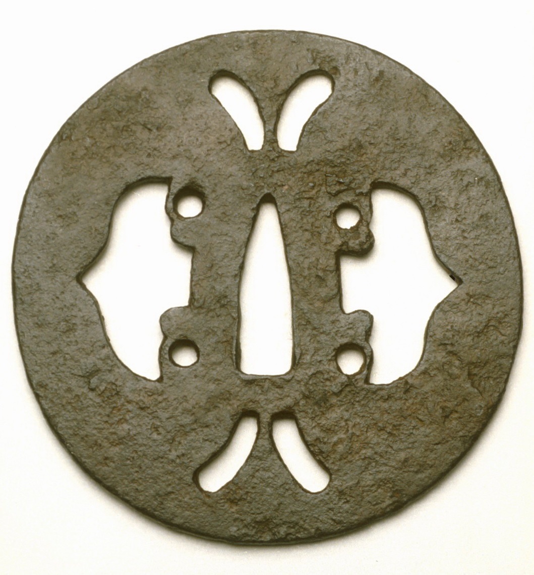 Round iron tsuba with a symmetrical cut-out design featuring butterfly and floral shapes.