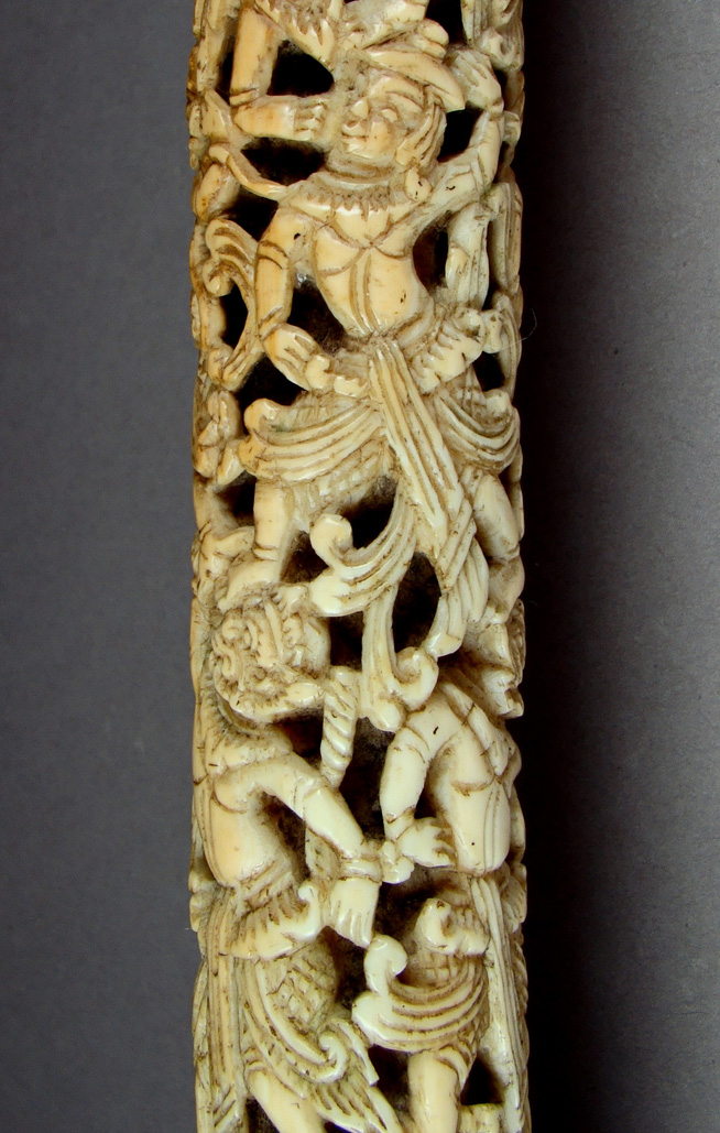 Intricately carved ivory object depicting multiple interwoven figures and decorative elements.