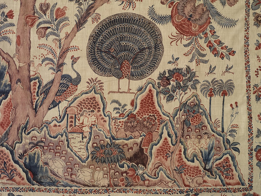 Textile complexe représentant un paon central avec une queue en forme d'éventail, entouré de motifs floraux et architecturaux.