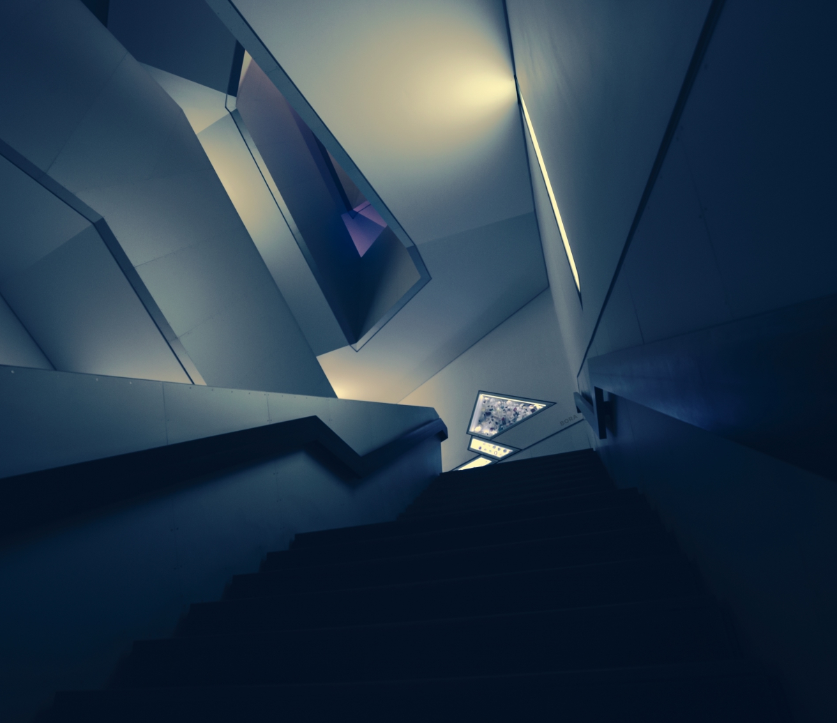 Modern architectural interior with angular, overlapping dark grey walls and a staircase leading downward.