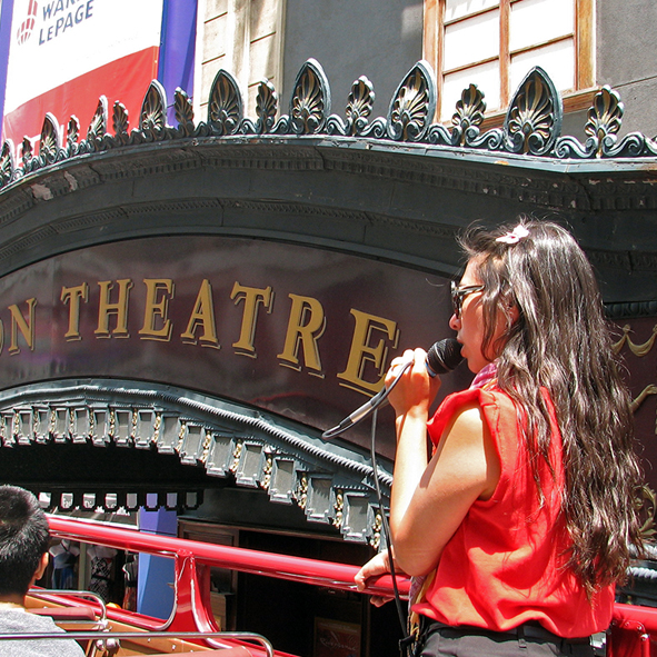 Double-decker bus passing by the Canon Theatre.
