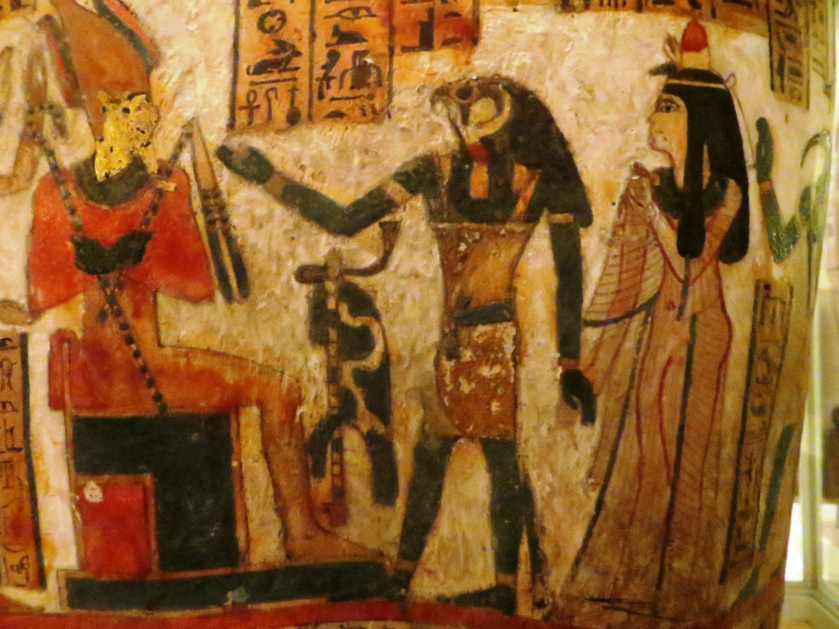 Ancient Egyptian painting showing three figures with hieroglyphics above their heads.