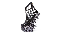 Black and white abstract woven chair with a stretched lattice design and hanging glass-like beads.
