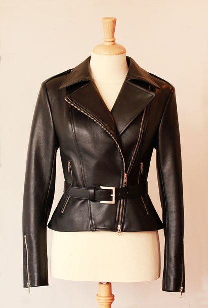 Black leather jacket with zipper details and a belt on a beige dress form.