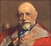Portrait of an older man with a bald head, white mustache and goatee, wearing a ceremonial robe.