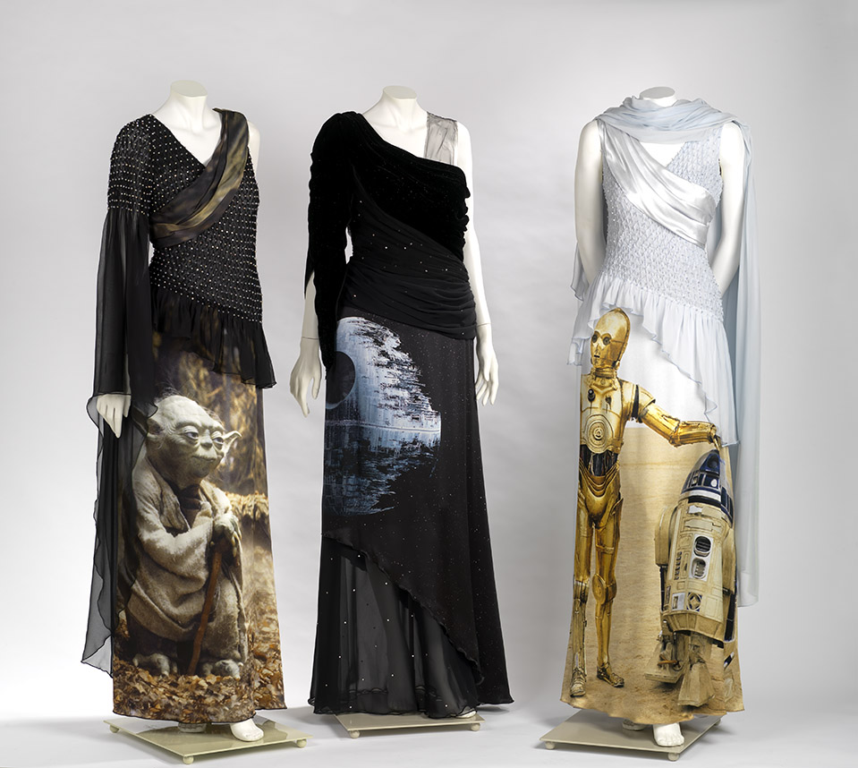 Three mannequins dressed in black and white gowns featuring Star Wars characters C-3PO and Yoda.