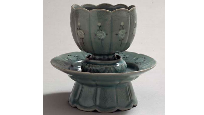 Overall frontal view of a Celadon glazed stoneware cup on a white background