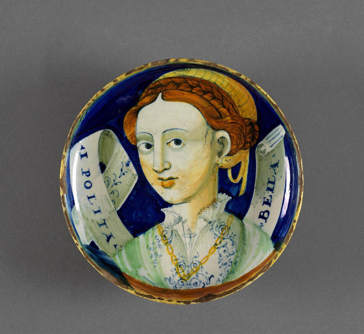 Assiette en poterie italienne avec une femme peinte dessus.