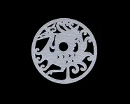 Circular jade disc carved with an abstract dragon and cloud motifs on a black background.