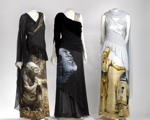 Trois mannequins vêtus de robes noires et blanches à l'effigie des personnages de Star Wars, C-3PO et Yoda.