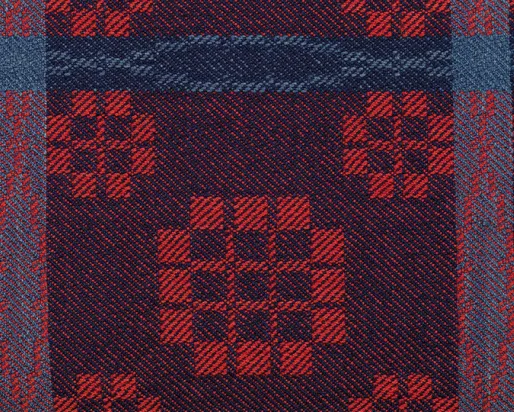 Détail d'une couverture tissée en rouge et bleu.
