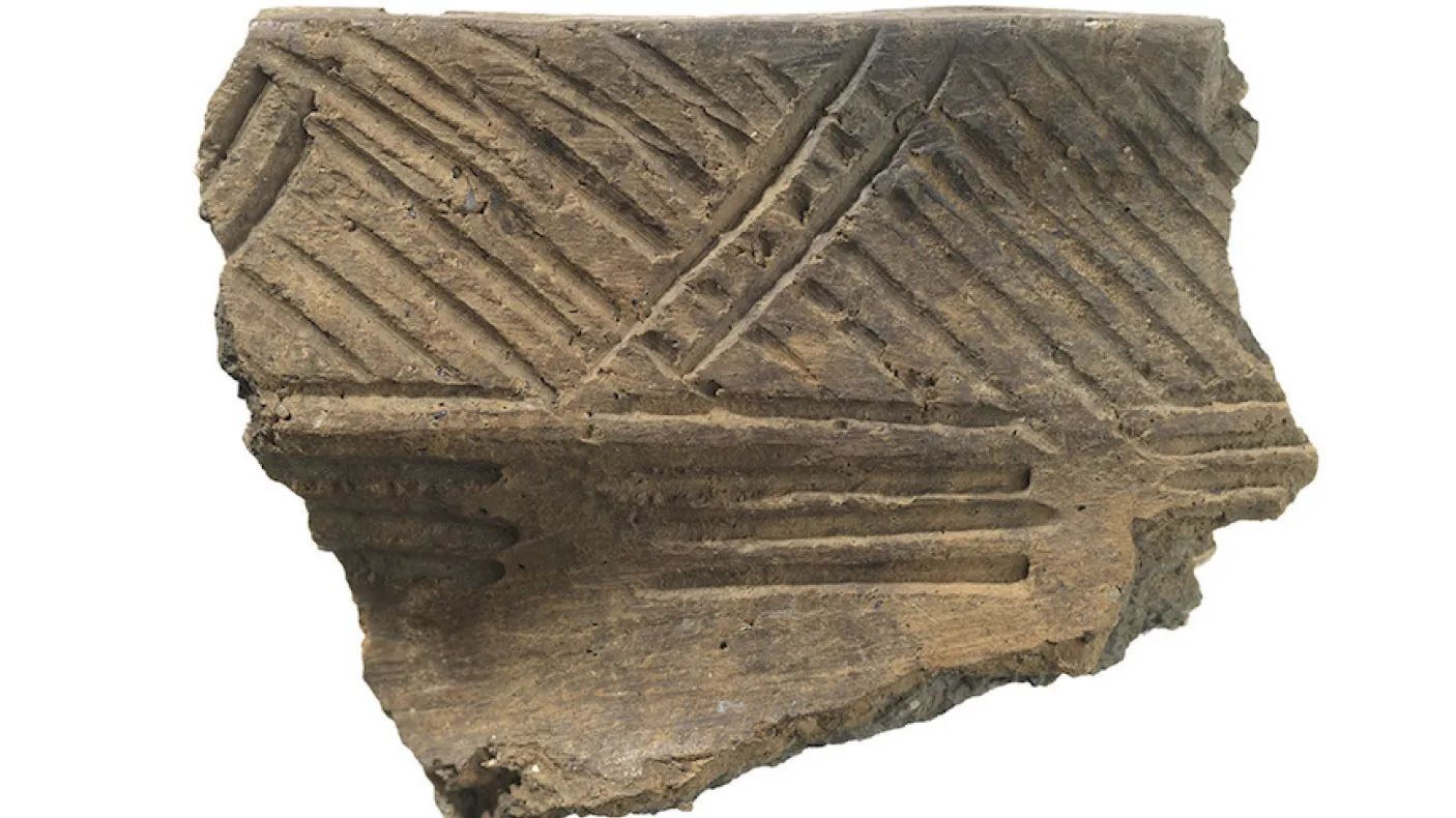 Fragment of pottery with incised diagonal and parallel line decorations.
