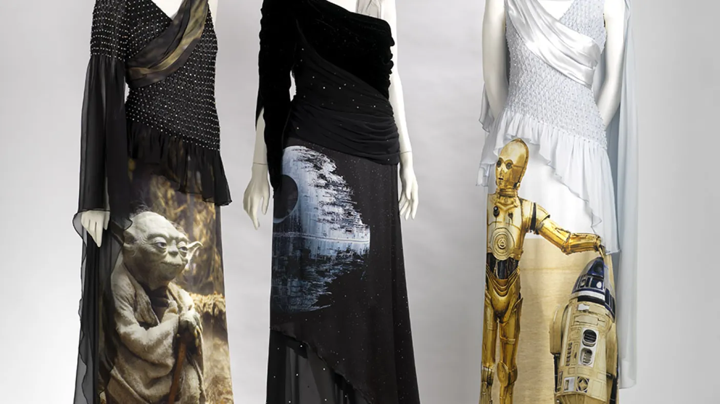 Trois mannequins vêtus de robes noires et blanches à l'effigie des personnages de Star Wars, C-3PO et Yoda.