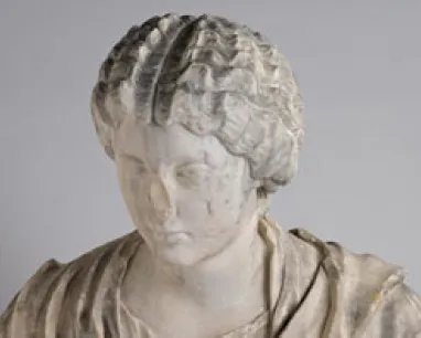 White marble bust sculpture of a woman with intricate braided hair, wearing draped clothing.
