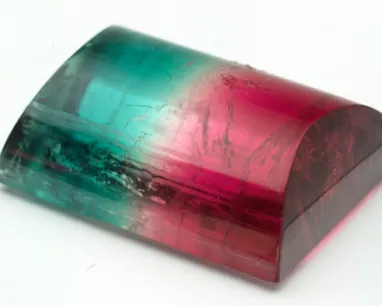 Bicolor polished gemstone with green on one side and pink on the other.