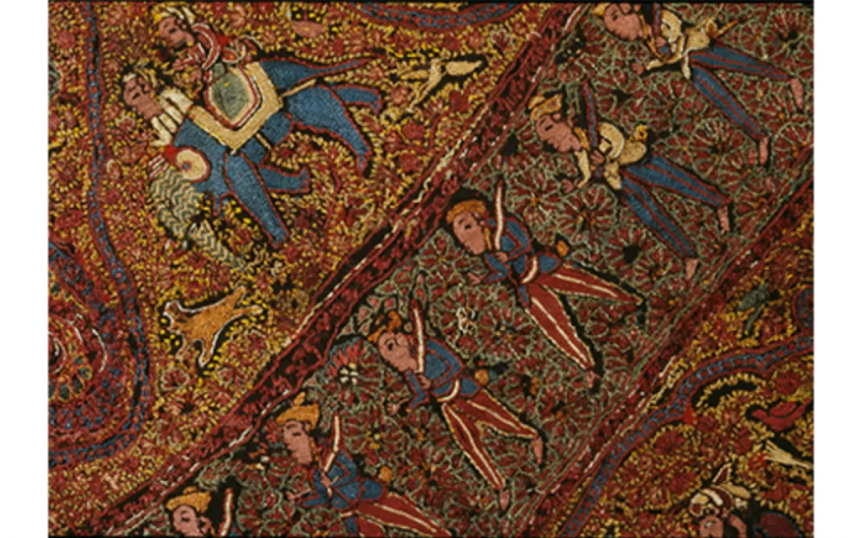 Textile coloré aux motifs complexes représentant des figures humaines, des éléphants et des motifs floraux sur un fond brun-rouge.