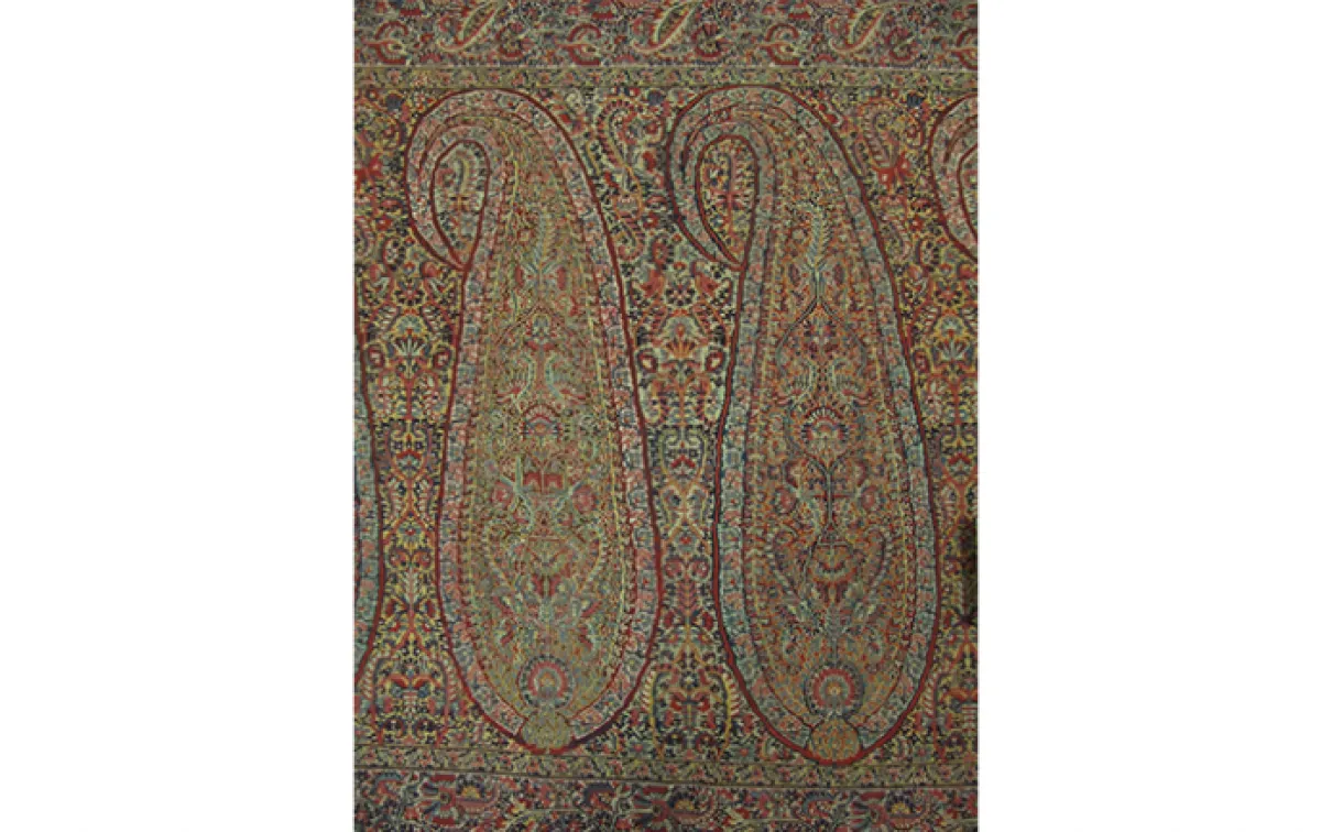 Textile rectangulaire complexe avec des motifs paisley et floraux ornés dans des tons de terre sourds.