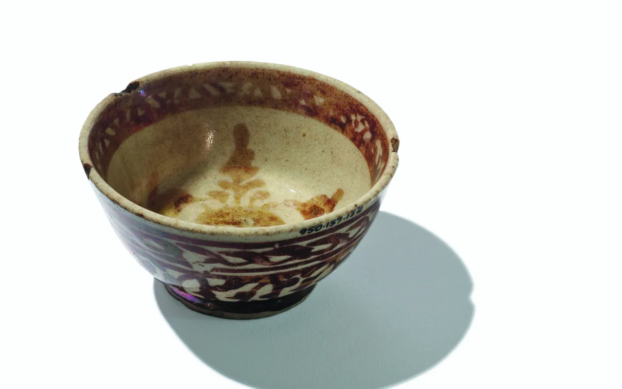 Bol en céramique avec des motifs floraux bruns et un intérieur beige, projetant une ombre sur un fond blanc.