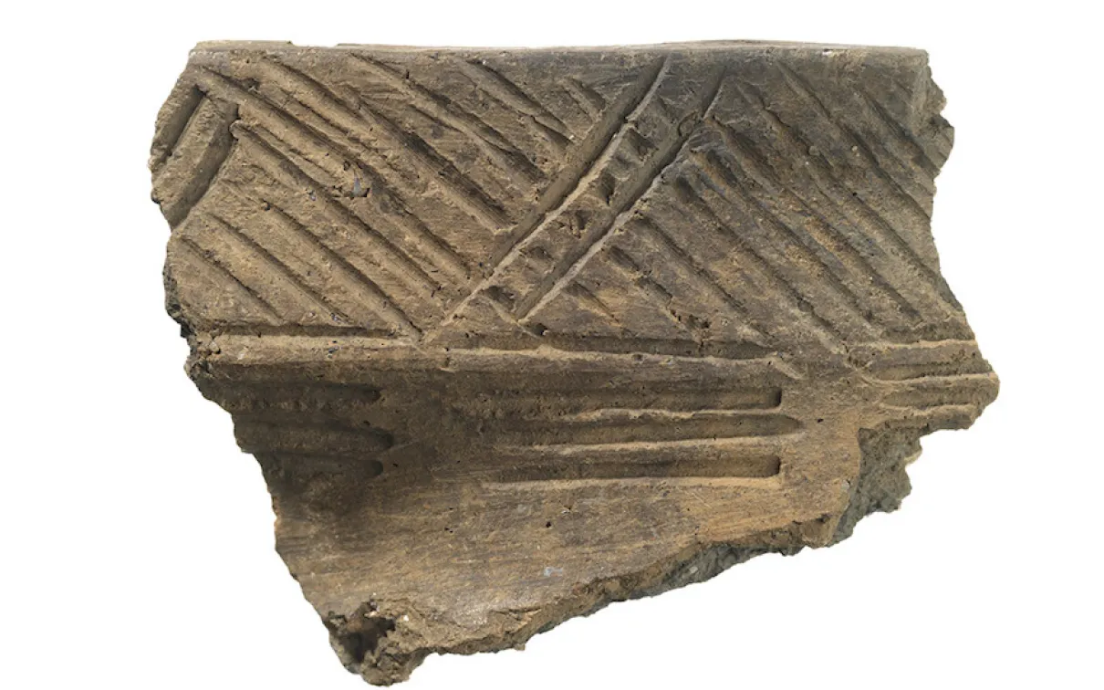Fragment of pottery with incised diagonal and parallel line decorations.