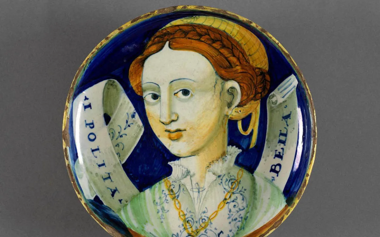 Assiette en poterie italienne avec une femme peinte dessus.