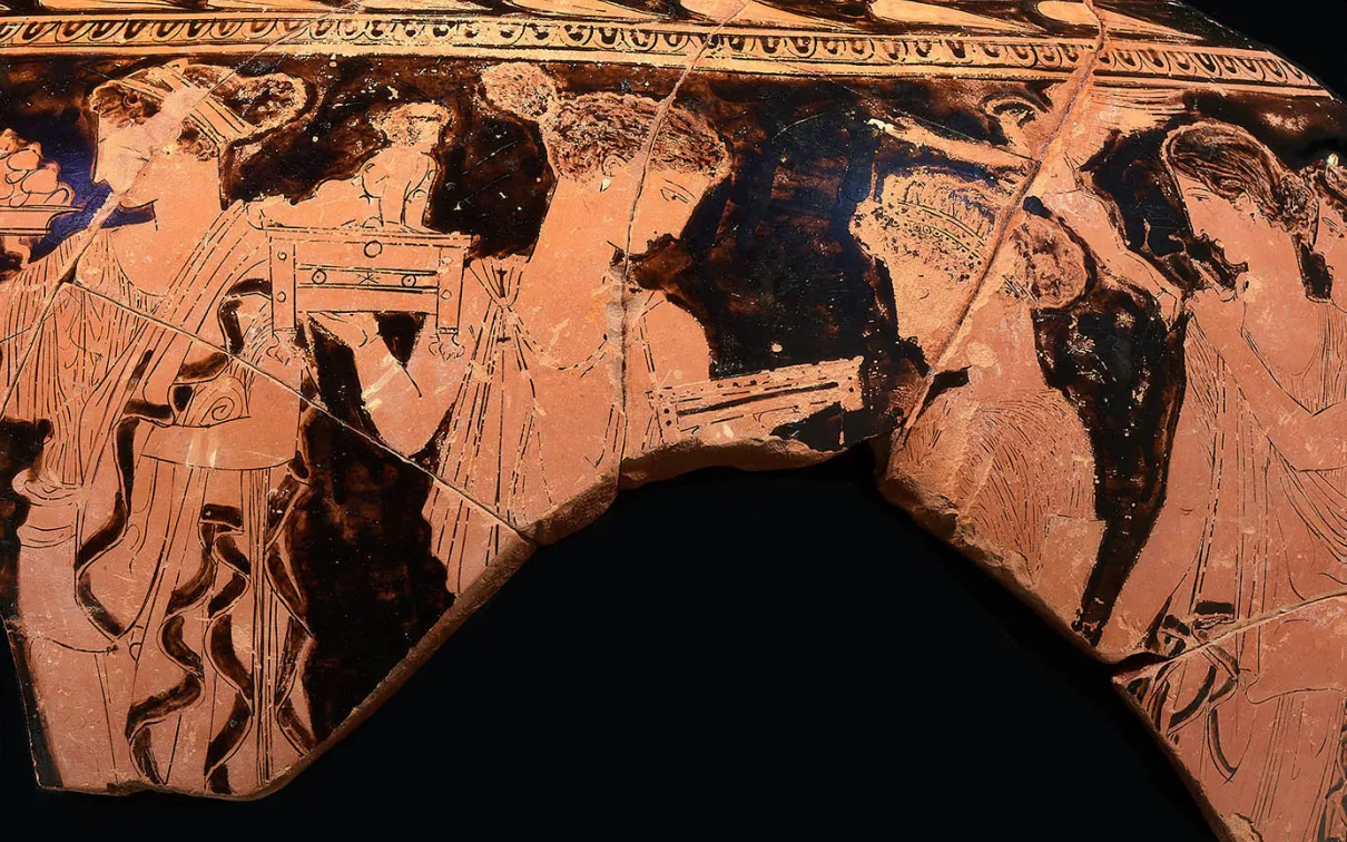 Fragment d'un vase grec à figures rouges représentant trois figures humaines drapées, dont l'une tient un bâton ou une lance.