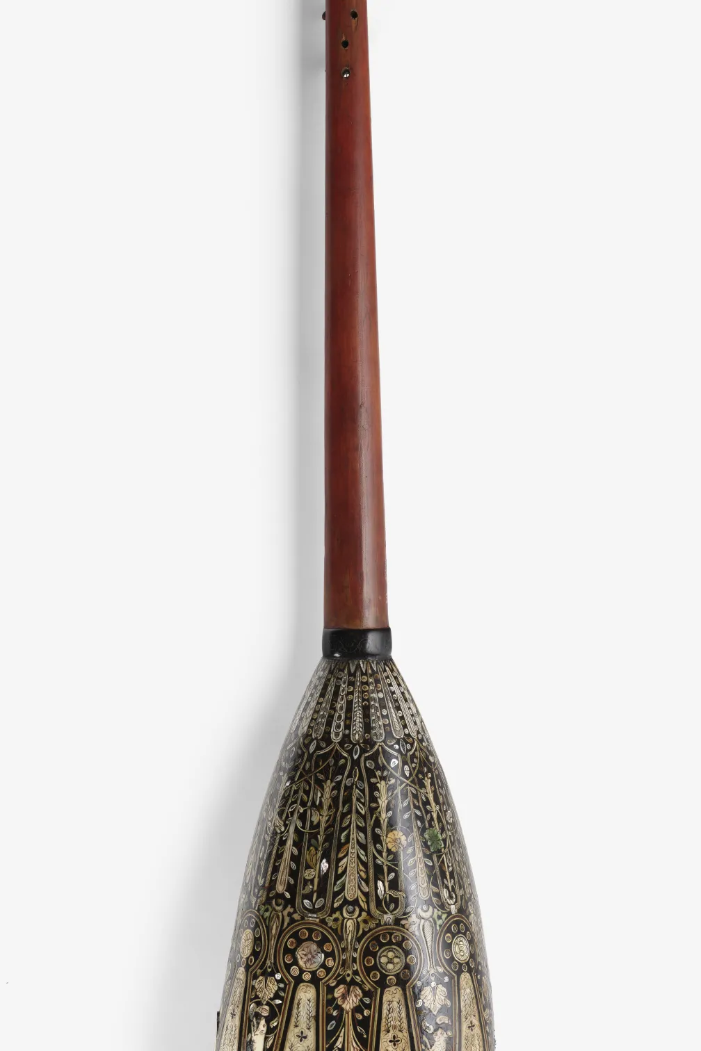 Long wooden paddle with a decorated blade featuring geometric and animal-shaped patterns.