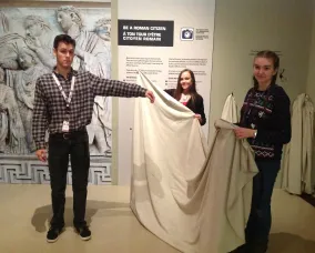 The young man holds his left arm out to the side.