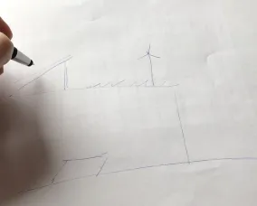 A student draws a blueprint of their sustainable school